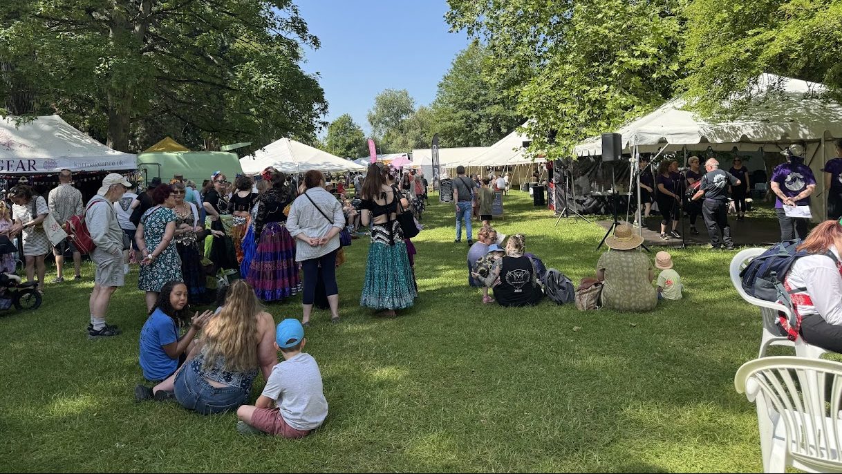 The festival crowds among the stalls and marquees of a sunny Island Park